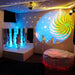 Calming Sensory Room Package with Kid standing on platform next to light blue bubble tube with red fiber optic lights and projector slide
