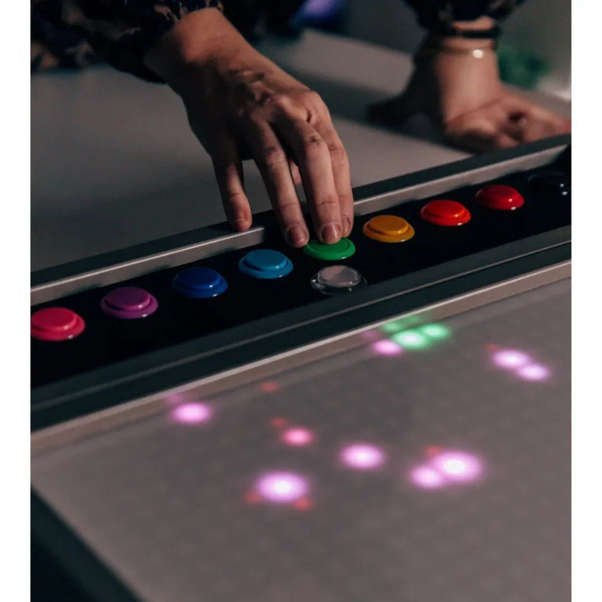 Closeup of hand on buttons of TFH Pixels Pro Interactive Sensory Panel