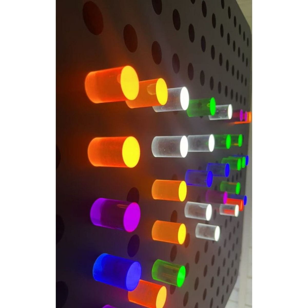 Closeup of the lit up PixelPop Interactive Sensory Light pegs on the board