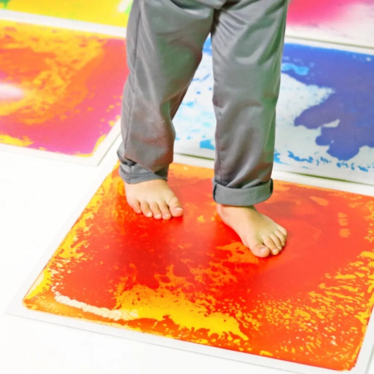 Closeup of two feet on a Large Square Liquid Sensory Floor Tile
