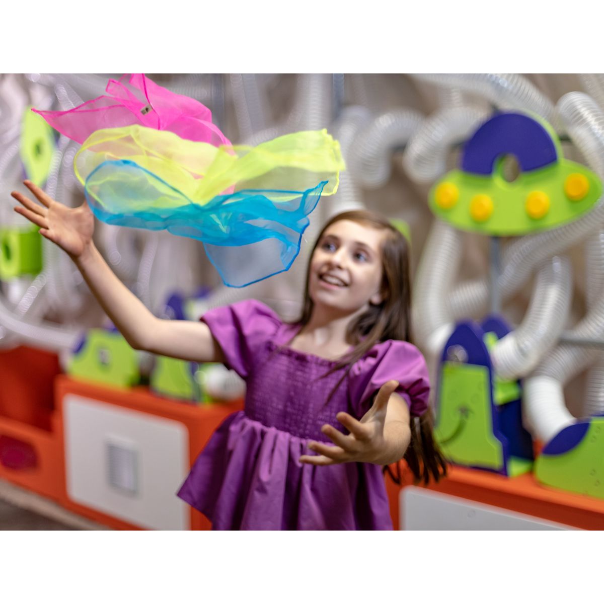 Girl catching a scarf in the air with the Ulitmate Scarf Launcher behind her