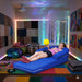 Girl lounging in the Vibroacoustic Long Lounger with other sensory items around her