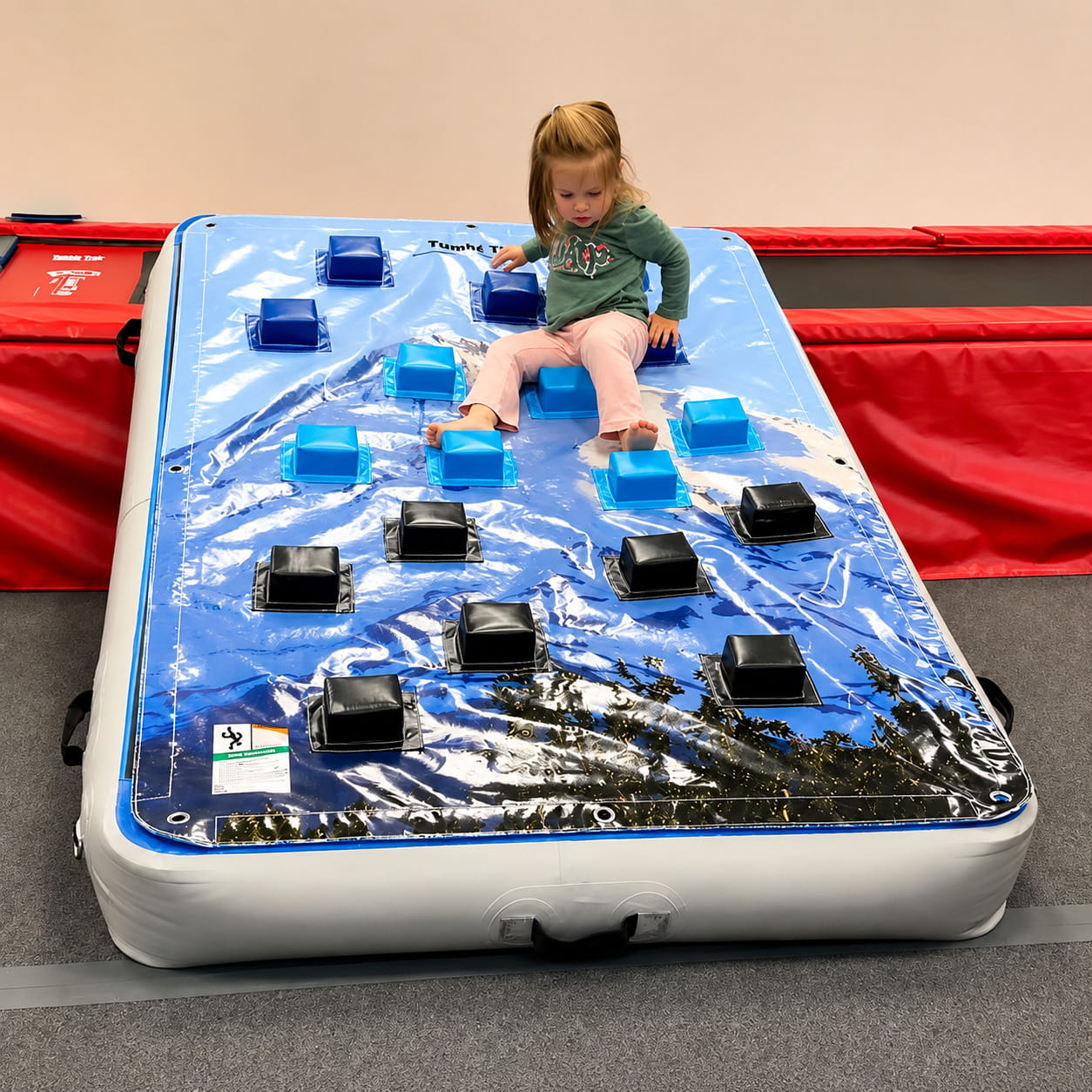 Girl playing on the Tumbl Trak Power Launch climbing wall overlay