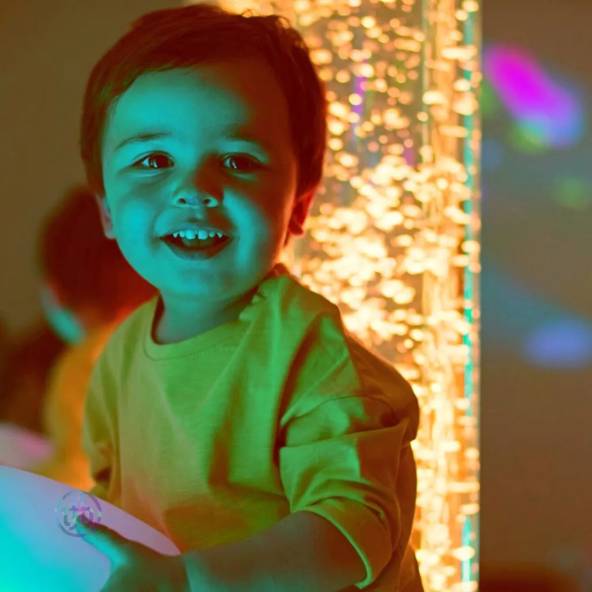 Interactive LED Bubble Tube behind smiling kid