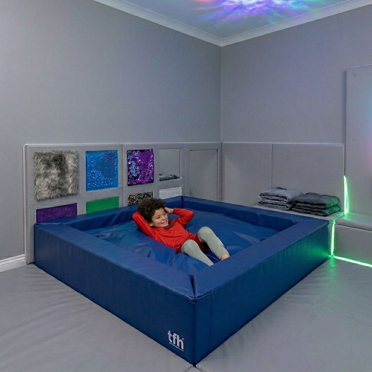 Kid in the Sensory Crash Pad Pit inside a sensory room