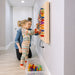 Kid playing with the LiteZilla Mini on wall with mom next to them