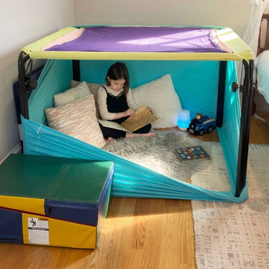 Kid reading a book inside the Boundex Cuddle Box