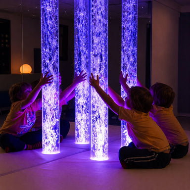Kid with hands around the lit up Calming Bubble Tube