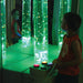 Kid changing the color to green on the Interactive Bubble Tube with controller