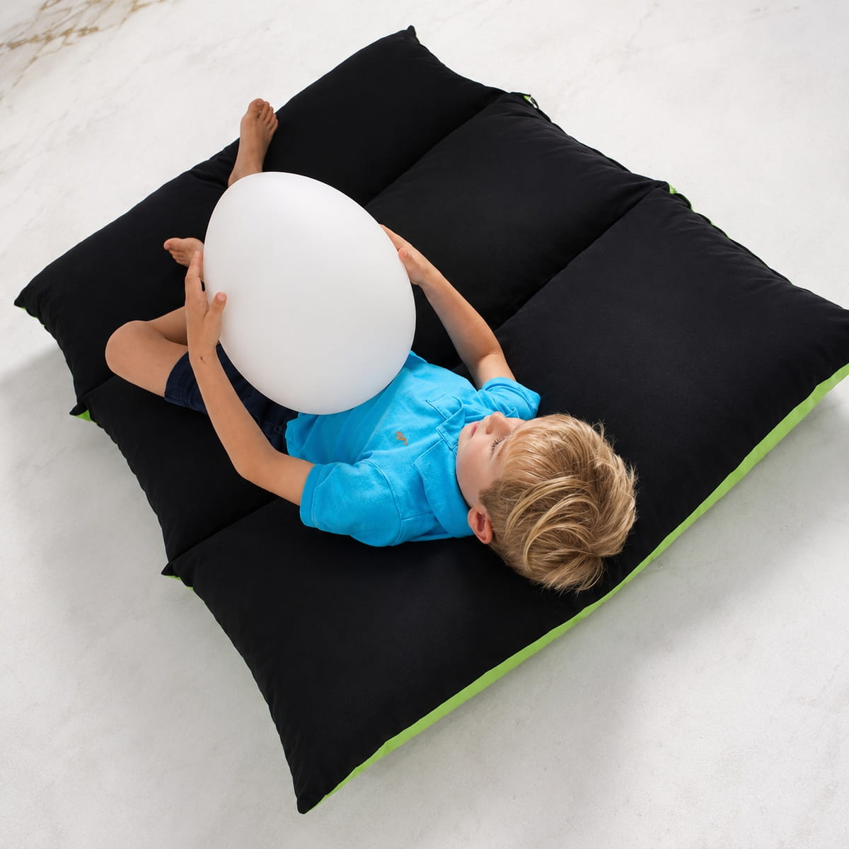 Kid laying down with the LED Mood Egg