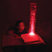 Kid looking up at the bright red TFH Tabletop Hurricane Tube in the dark