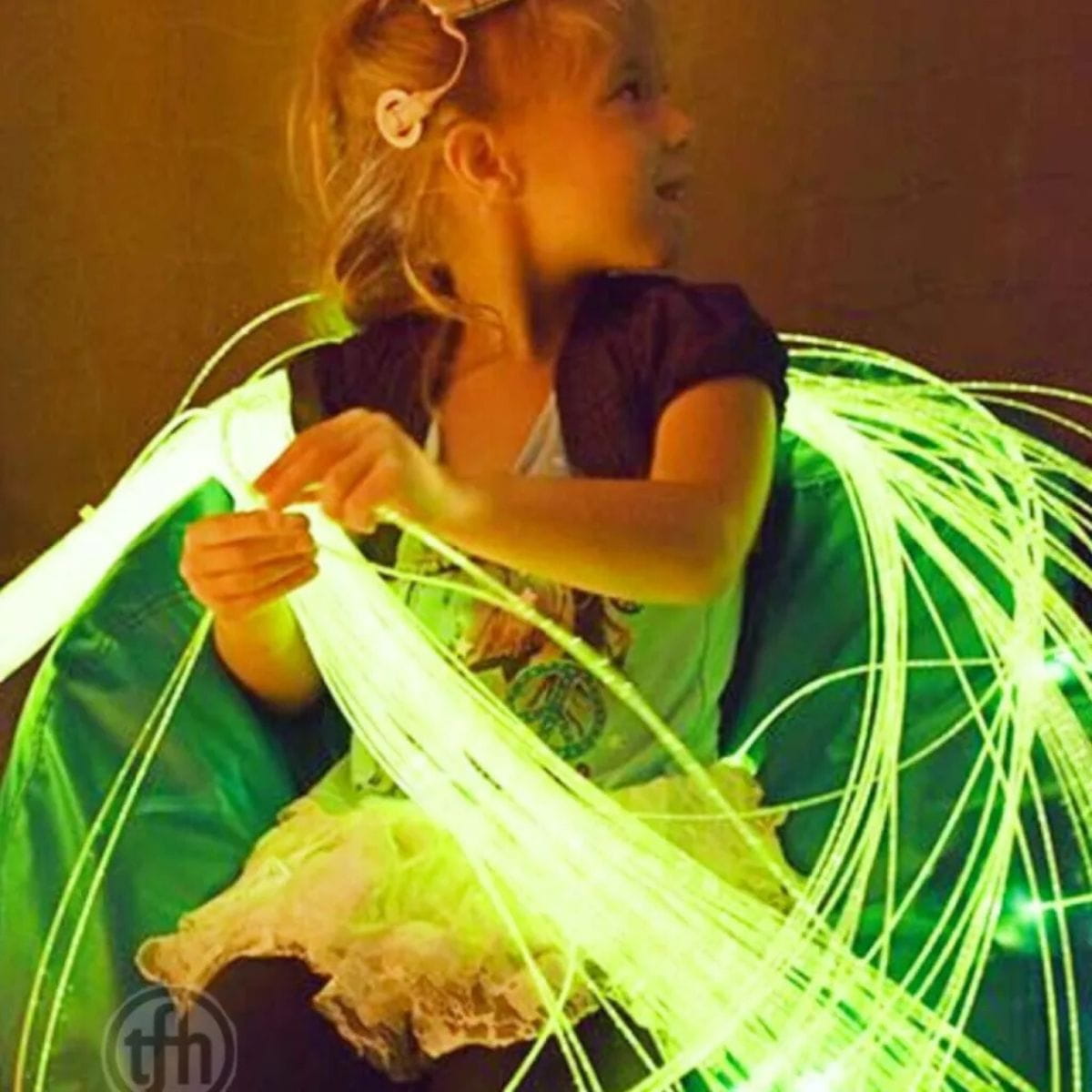 Kid playing with Interactive Fiber Optic Spray tails in green color