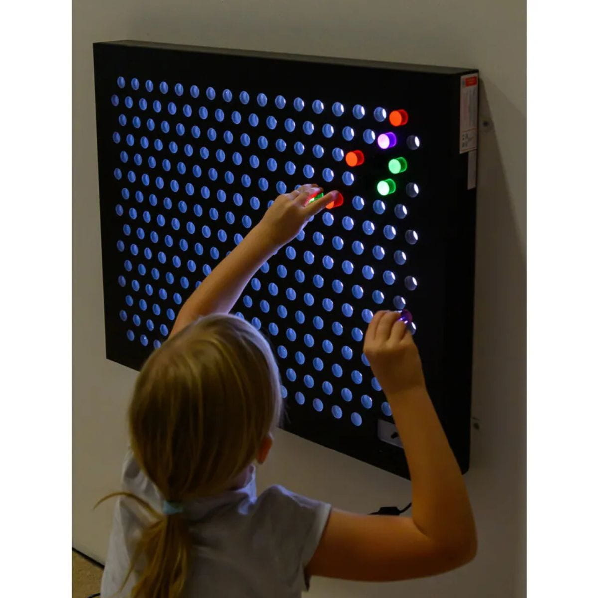 Kid putting pegs into the TFH Rod Wall Light Panel