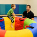 Kid sitting on edge of Sensory Fitness Wheel with adult near