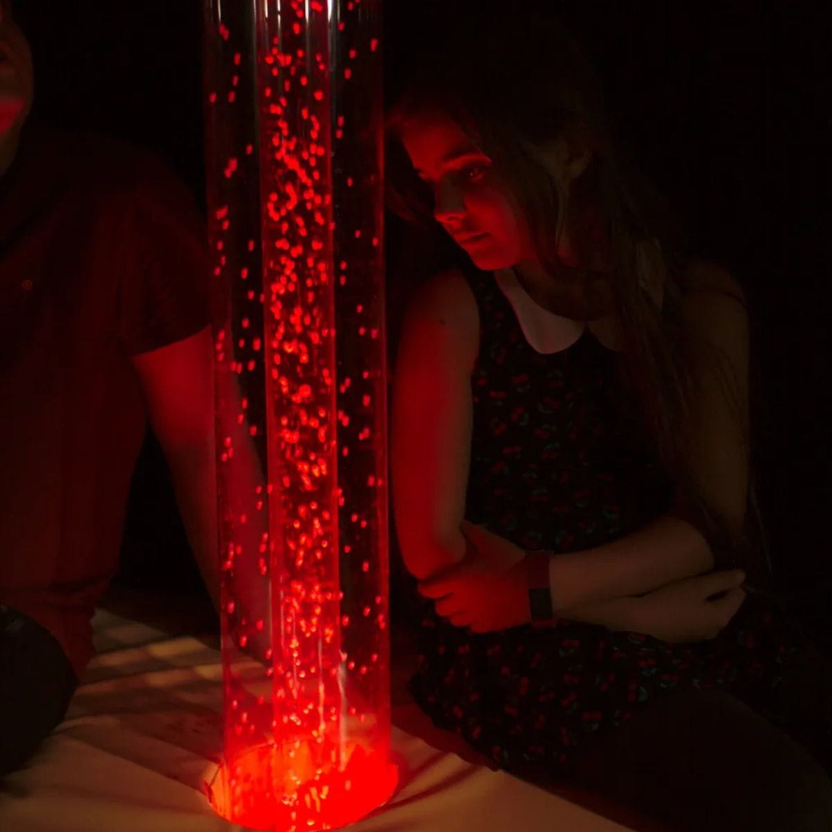 Kid staring at the Interactive Hurricane Tube in red 