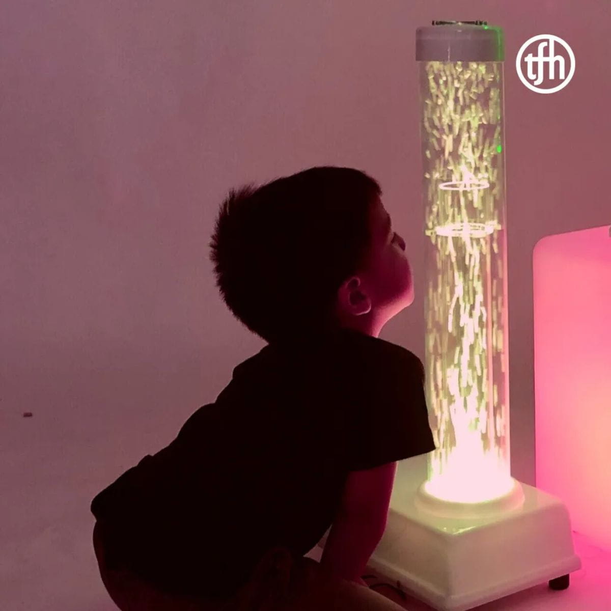 Kid up close watching the TFH hurricane tube sensory