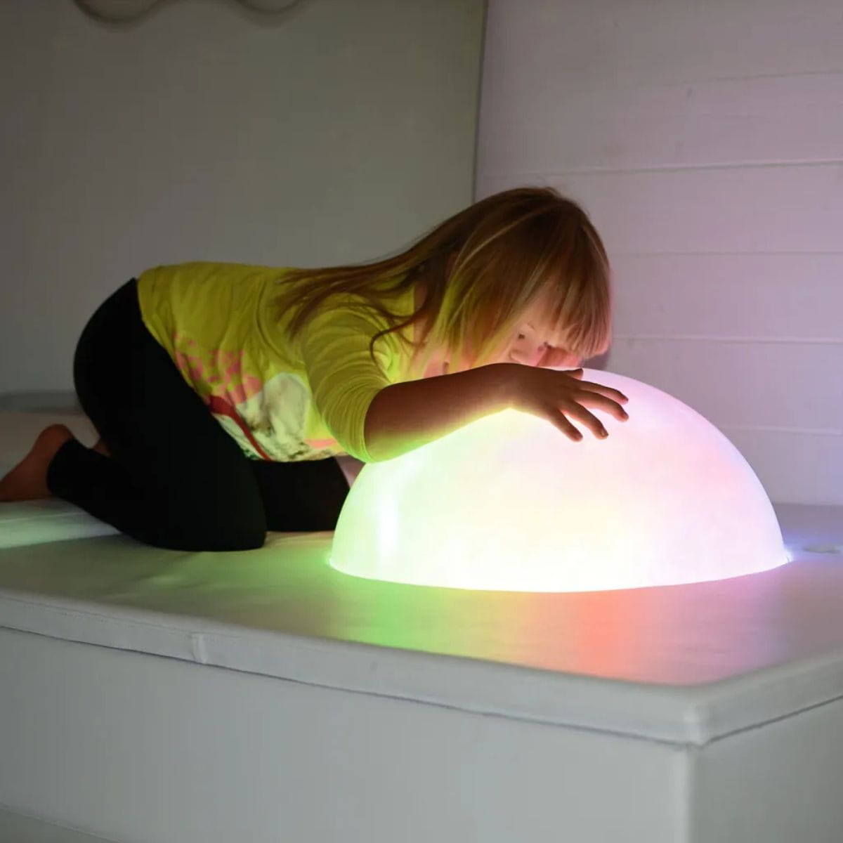 Kid with face and hands on the glowing Sound Light Dome Platform