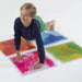 Kid with hands and feet on Large Square Liquid Sensory Floor Tiles