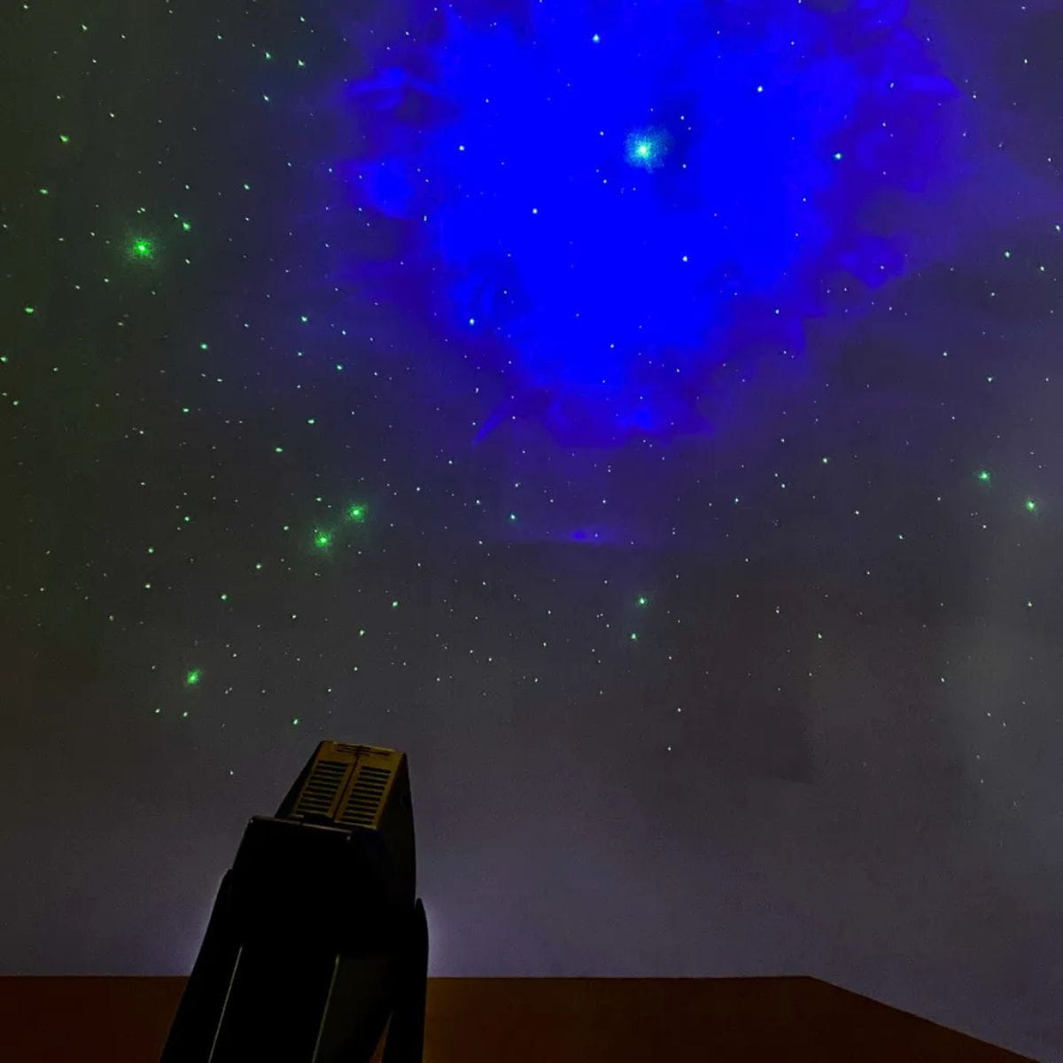 LED Laser Star Projector in dark room with stars and clouds on wall