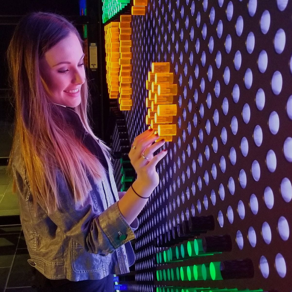 Lady putting the litepins into 12x6 LiteZilla Lite Brite Wall