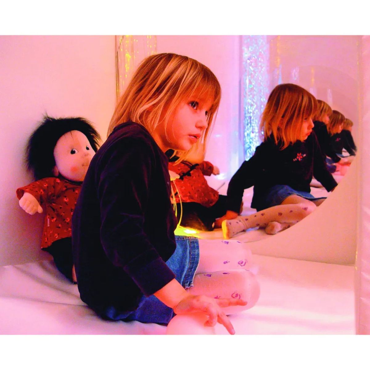 Little girl in the Portable Sensory Den with her doll and reflection in the mirror