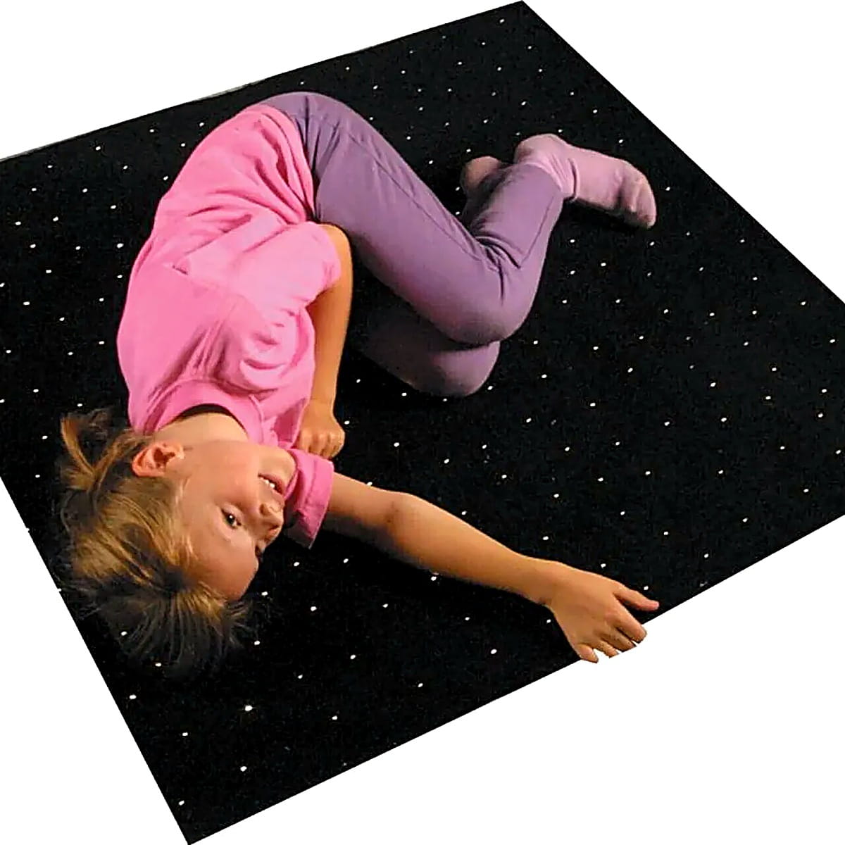 Little girl laying on Fiber Optic Starfield Carpet looking up