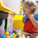 Little kid grabbing balls from the bin of LiteZilla Ultimate Ball Launcher for Kids