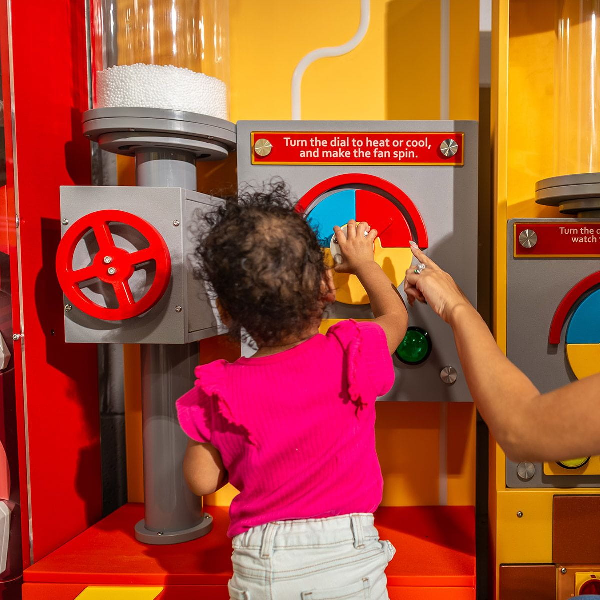 Little kid turning the knob to start the LiteZilla Hurricane Interactive Tube