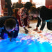 People looking closer at the Budii Interactive Projector image on the floor