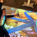 Person laying on omiVista Mobii Interactive Projector image on floor