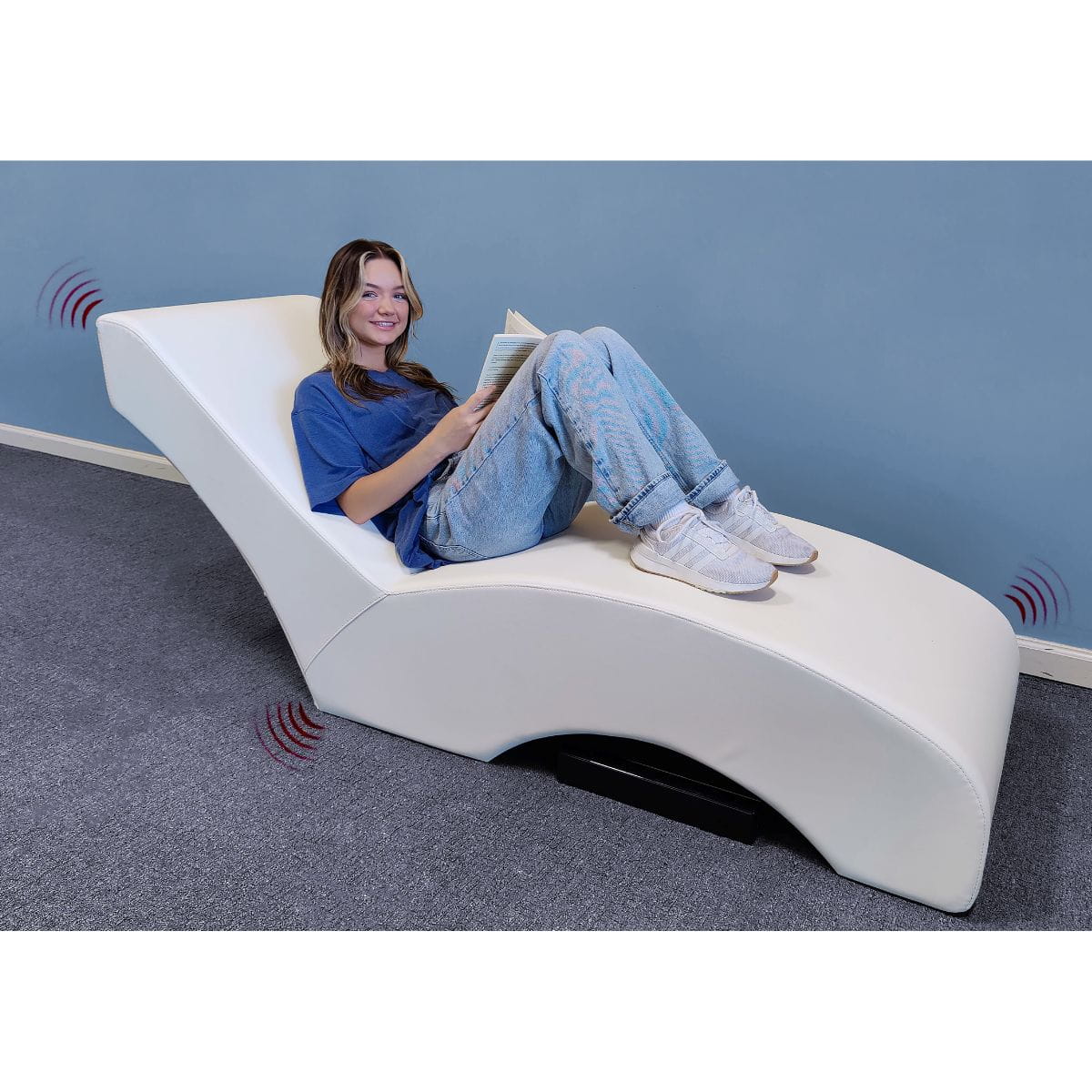 Person lounging on Vibro Acoustic Lounger with a book in their hands