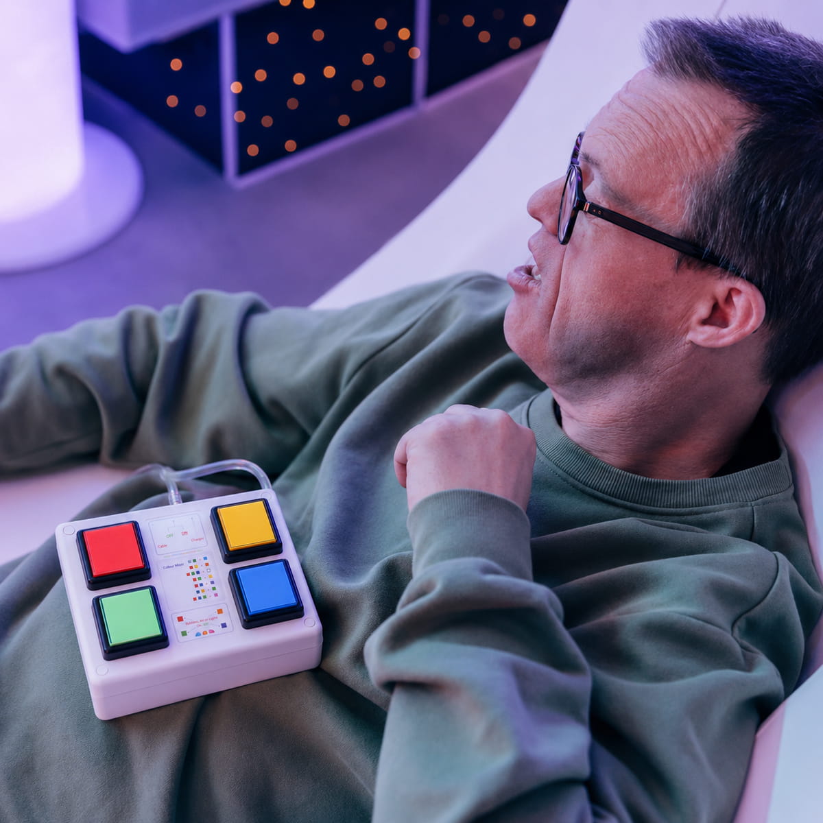 Person with TFH 4 Button Wireless Color Controller on belly while laying down