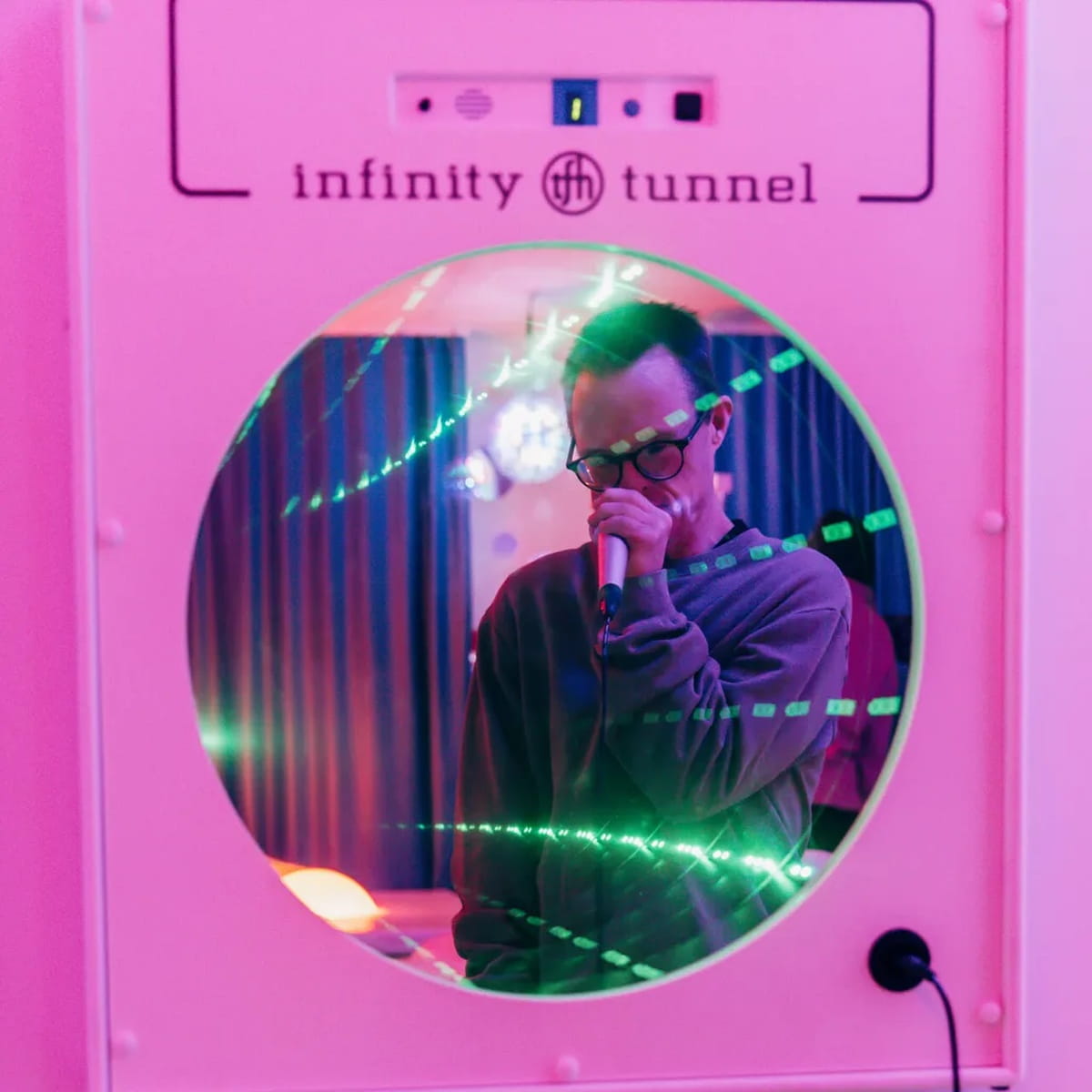 Reflection of person singing into the LED Infinity Tunnel