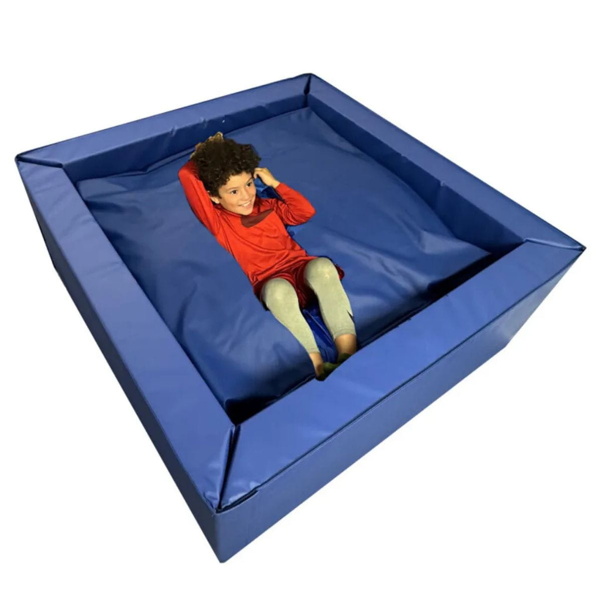 Smiling kid laying in the Sensory Crash Pit