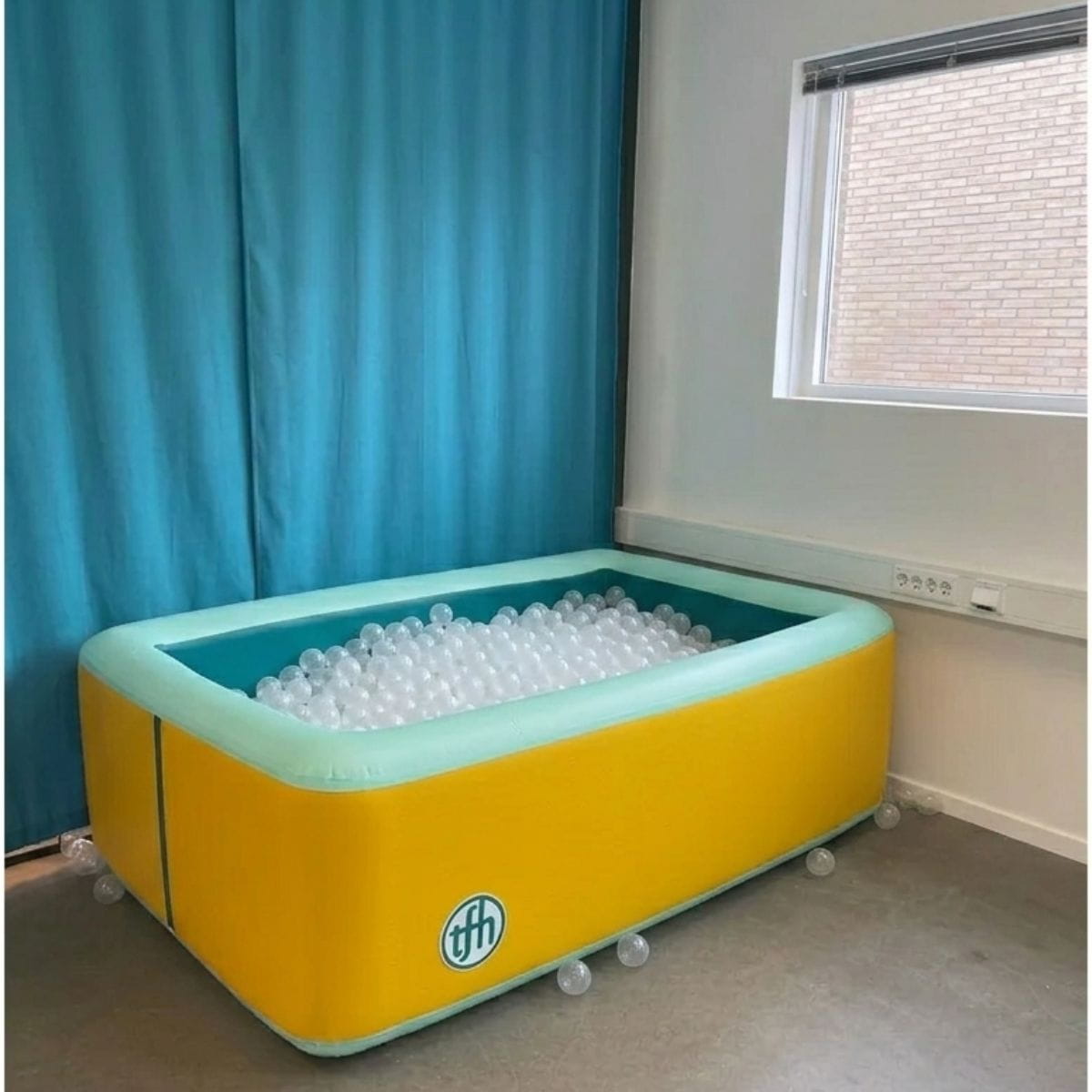 TFH Inflatable Ball Pit Pool with clear balls in it