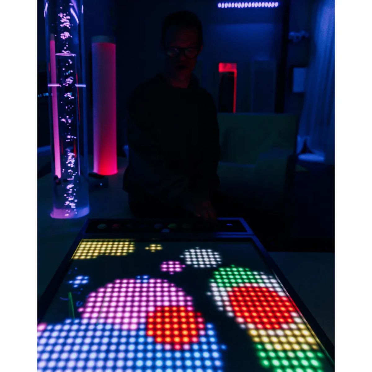 TFH Pixels Pro Interactive Sensory Panel in the dark with person making a design