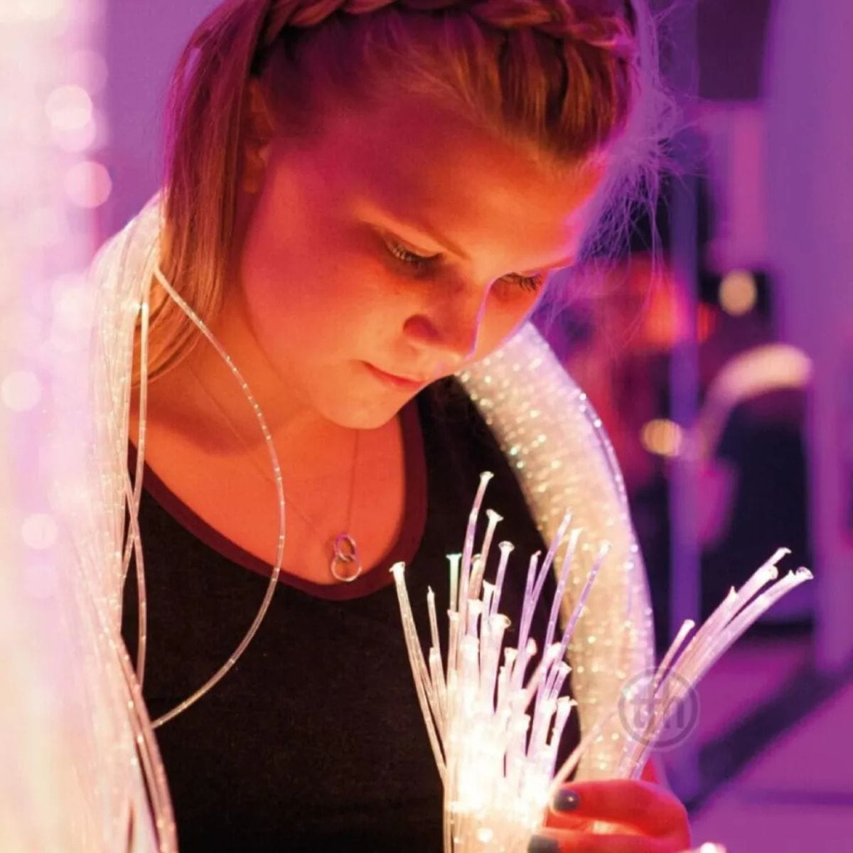 TFH fiber optic tails wrapped around a kid that is staring at the tails lit up