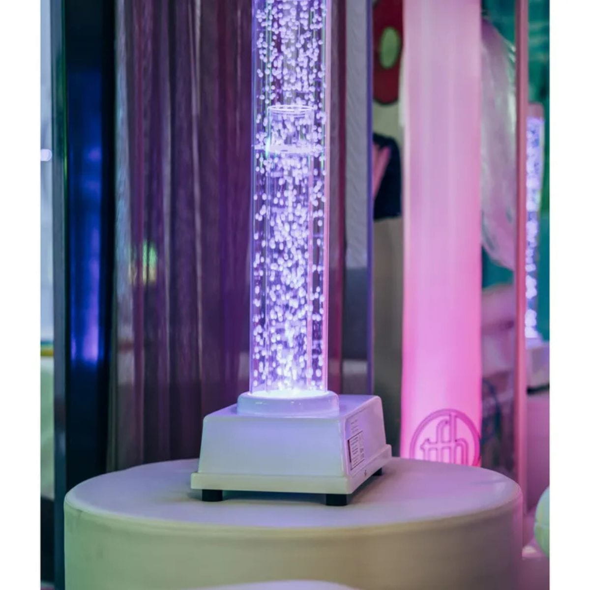 Tabletop Hurricane Tube sitting on platform glowing purple