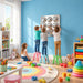 Three kids on stools with another on the floor touching the Bubble Wall Mirror Sensory Panels