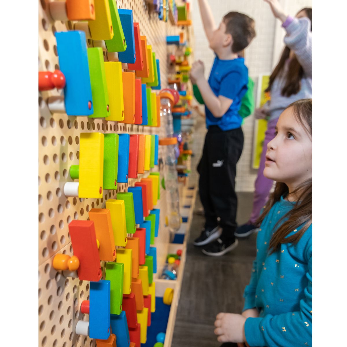 Three kids playing on the LiteZilla Kidworx Interactive Game Board