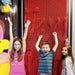 Three kids with excitement on their faces standing in front of the Clone Box Giant Pin Wall