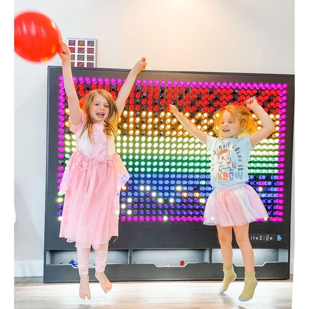 Two girls celebrating their design on the 6x5 LiteZilla Lite Brite Wall