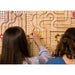 Two girls playing the game Magnet Maze Builder on the Kidworx Interactive Game Board