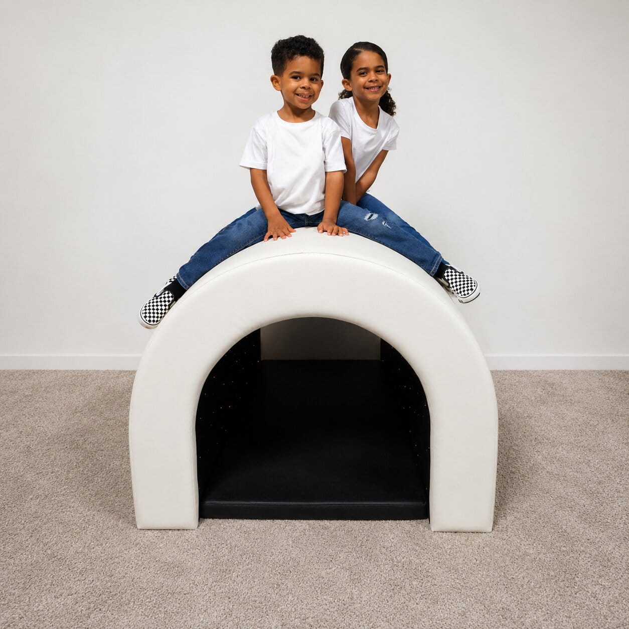 Two kids on the top of the Kid smiling while laying in the Experia Tranquility Fiber Optic Sensory Tunnel