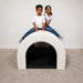 Two kids on the top of the Kid smiling while laying in the Experia Tranquility Fiber Optic Sensory Tunnel
