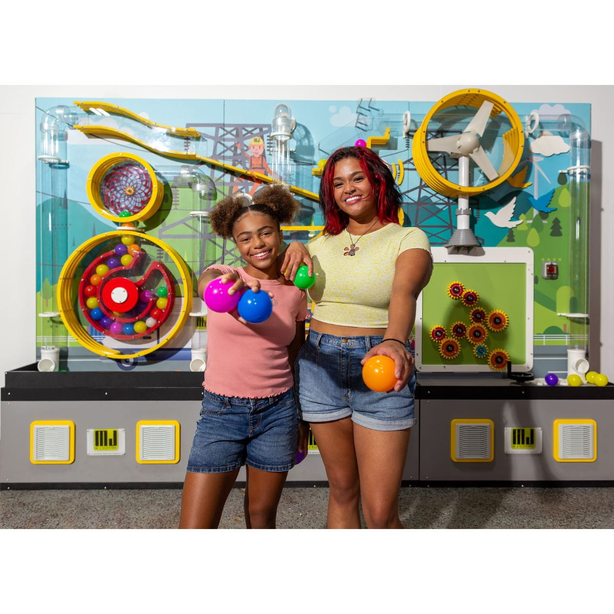 Two kids holding the balls in front of the LiteZilla Ulitmate Ball Launcher