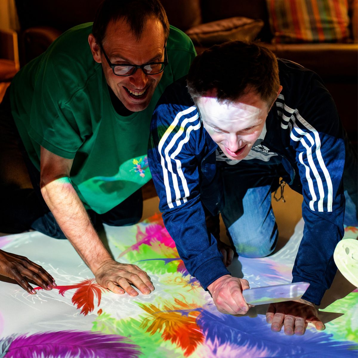 Two people smiling at image from Budii Interactive Projector