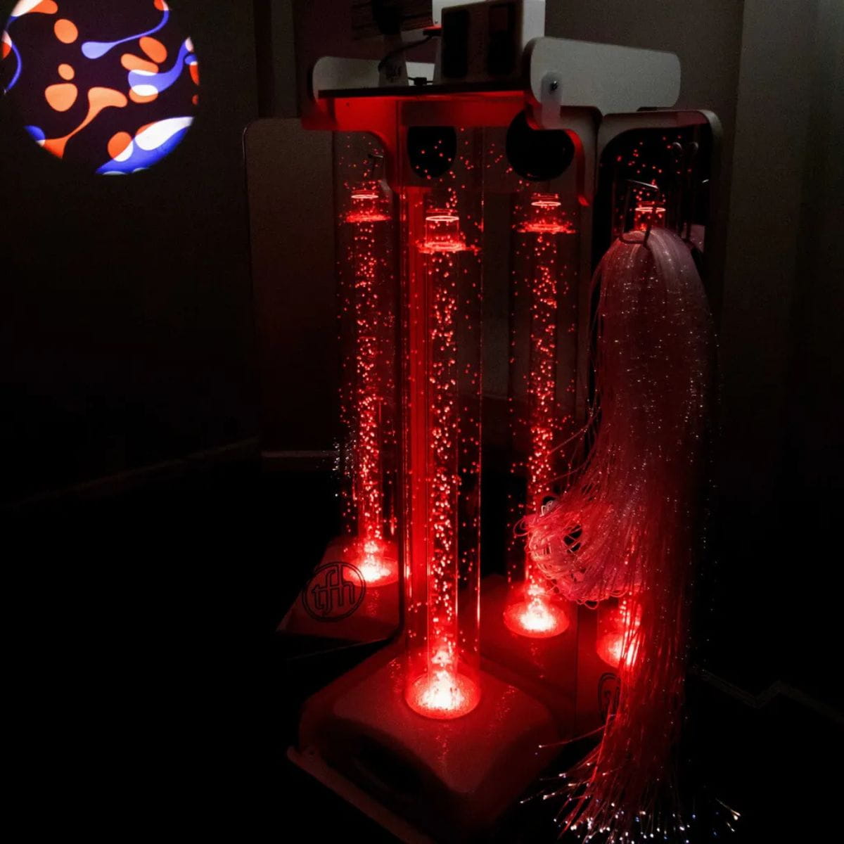 Vecta Delight Mobile Sensory Station in the dark with pattern on wall and bubble tube in red