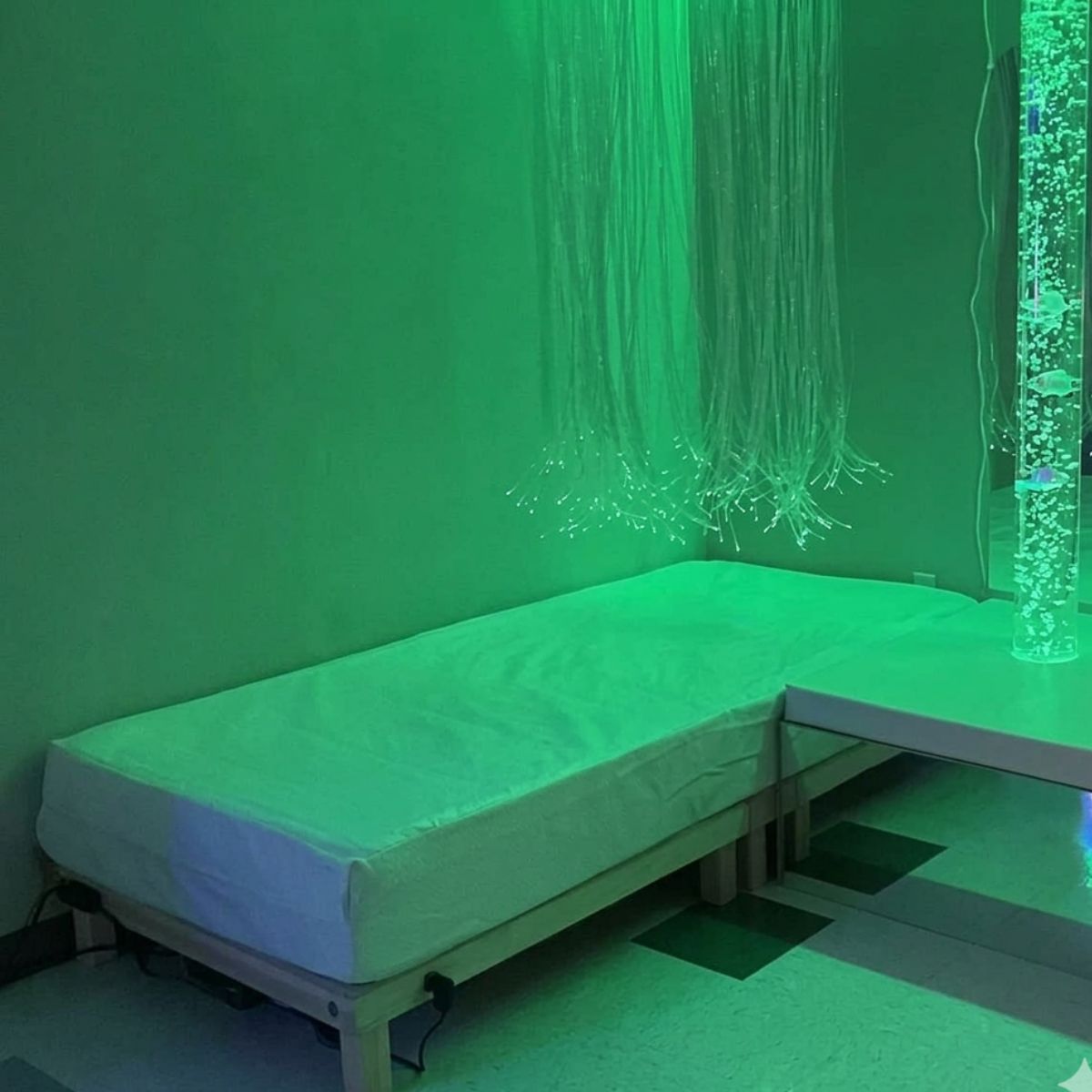 Vibroacoustic Waterbed next to bubble tube and sensory lights in green