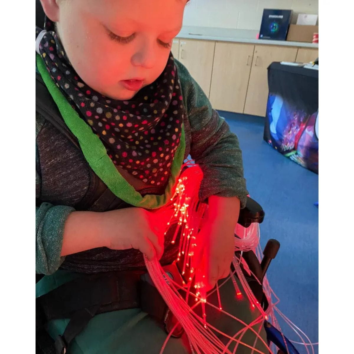 Young kid playing with Interactive Fiber Optic Spray that glows red